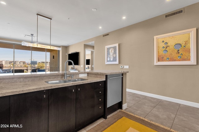 kitchen with light tile flooring, pendant lighting, light stone counters, dishwasher, and sink