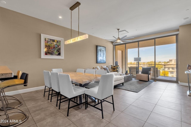 tiled dining space featuring ceiling fan and floor to ceiling windows