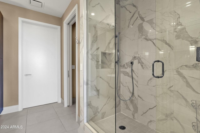 bathroom with tile flooring and a shower with shower door