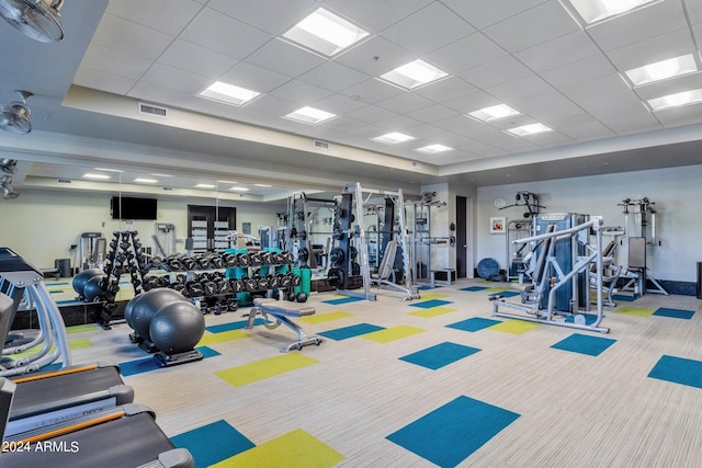 gym featuring a drop ceiling and light colored carpet