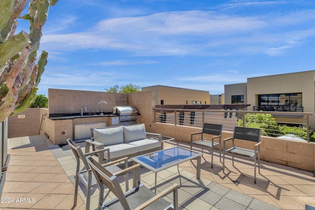 view of terrace with a grill, a balcony, and an outdoor kitchen