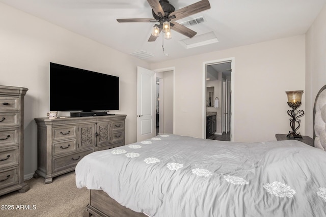 bedroom featuring visible vents, attic access, light carpet, connected bathroom, and ceiling fan