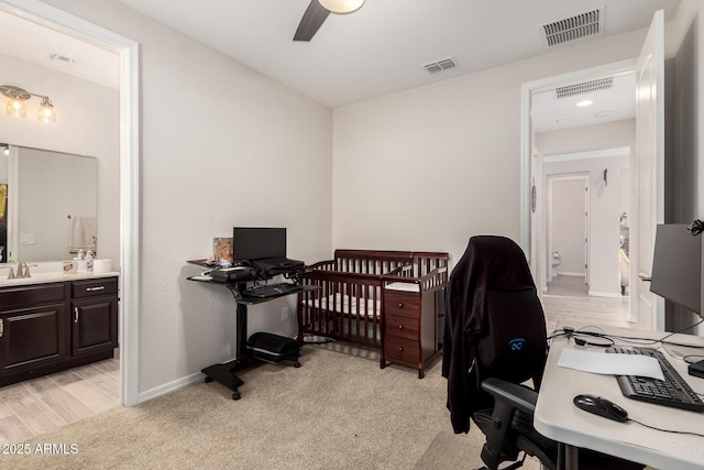 office featuring a ceiling fan, visible vents, and a sink