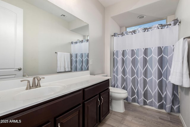 bathroom with curtained shower, visible vents, toilet, vanity, and wood finished floors