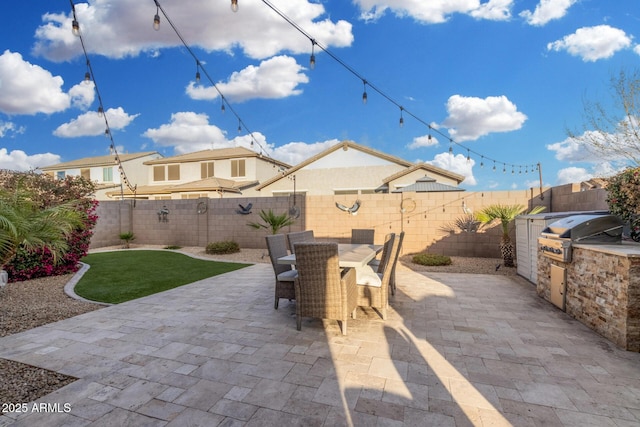 view of patio featuring area for grilling, outdoor dining space, grilling area, and a fenced backyard