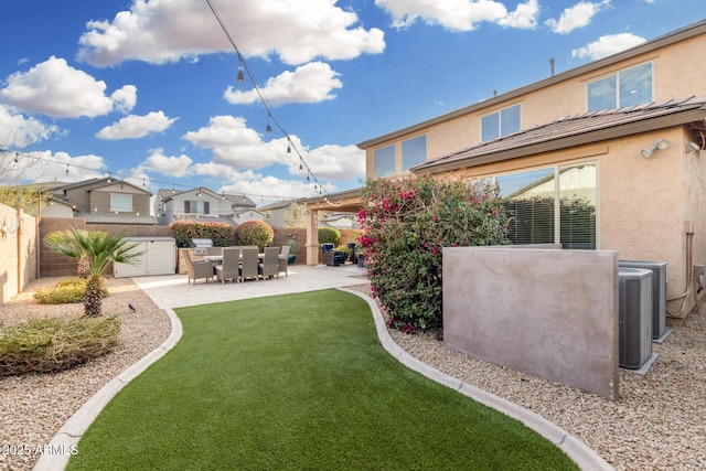 view of yard featuring a patio area, a fenced backyard, and central AC unit