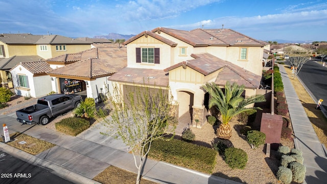 view of front of home featuring a tiled roof, concrete driveway, and a residential view