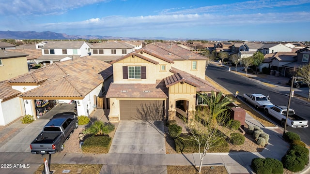 view of front of home featuring driveway, an attached garage, a residential view, and stucco siding