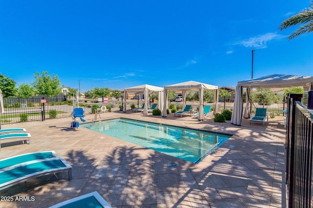 community pool featuring fence, a patio, and a gazebo