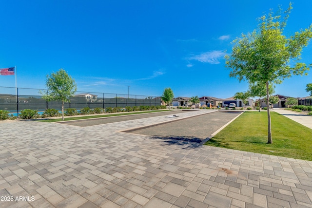 view of property's community with fence and a yard