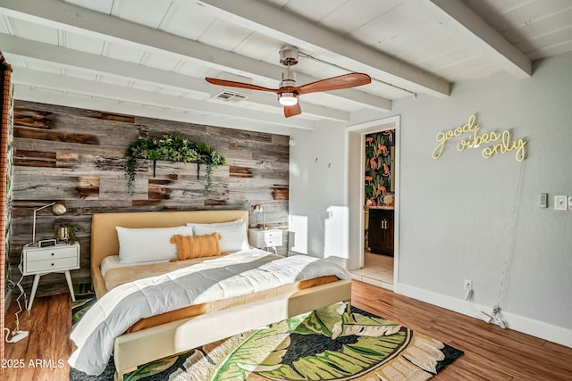 bedroom with wooden walls, ceiling fan, and wood-type flooring