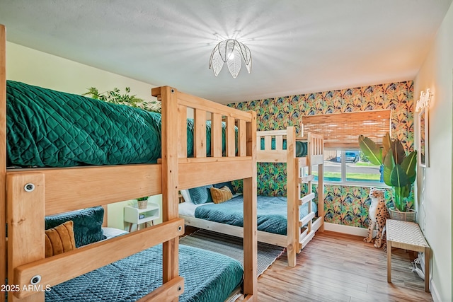 bedroom featuring wood-type flooring and a notable chandelier