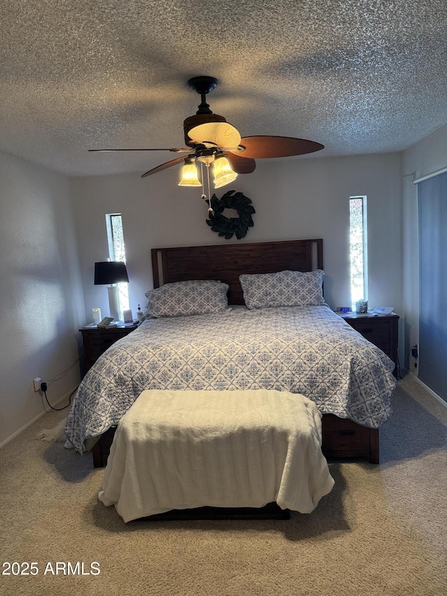 bedroom with ceiling fan, carpet floors, and a textured ceiling