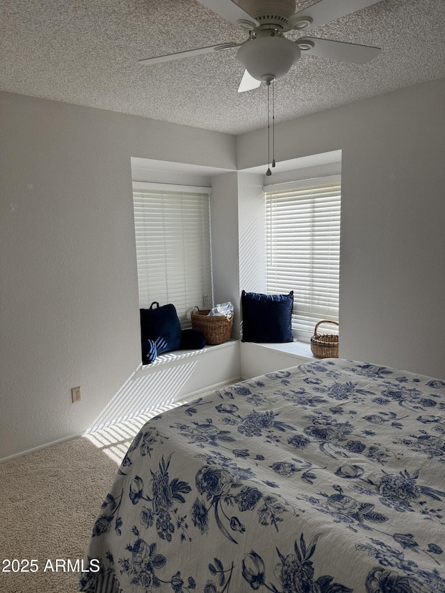 bedroom featuring ceiling fan, carpet flooring, and a textured ceiling