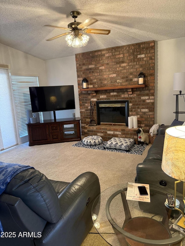 living room featuring ceiling fan, a brick fireplace, carpet floors, and a textured ceiling