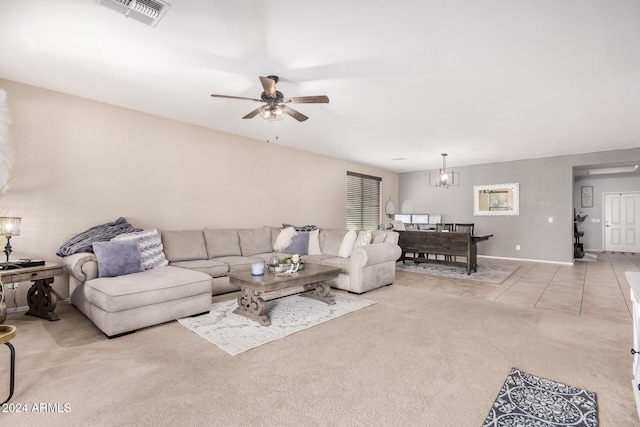 tiled living room featuring ceiling fan with notable chandelier