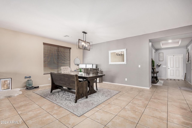 tiled dining space featuring a raised ceiling