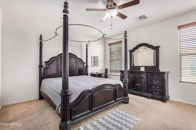 bedroom featuring multiple windows, ceiling fan, and light colored carpet