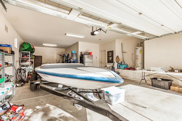 garage featuring gas water heater, a garage door opener, and stainless steel refrigerator