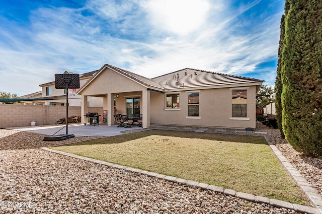 rear view of house featuring a yard and a patio