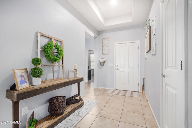 tiled foyer entrance featuring a tray ceiling