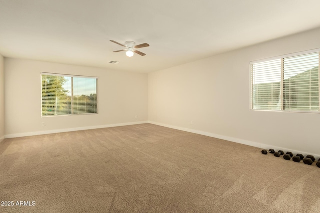 carpeted spare room with ceiling fan