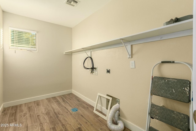 clothes washing area featuring hardwood / wood-style flooring and hookup for an electric dryer