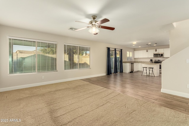 unfurnished living room with ceiling fan and light wood-type flooring