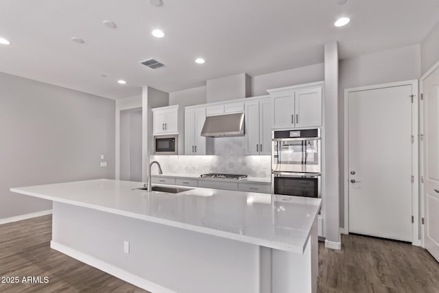 7492 E Via De Luna Dr, Scottsdale, AZ 85255 - kitchen featuring range hood, stainless steel appliances, white cabinets, dark wood finished floors, and a kitchen island with sink