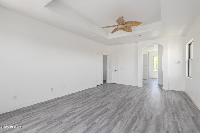 2302 S Canfield, Mesa, AZ 85209 - unfurnished room with a tray ceiling, ceiling fan, arched walkways, and wood finished floors