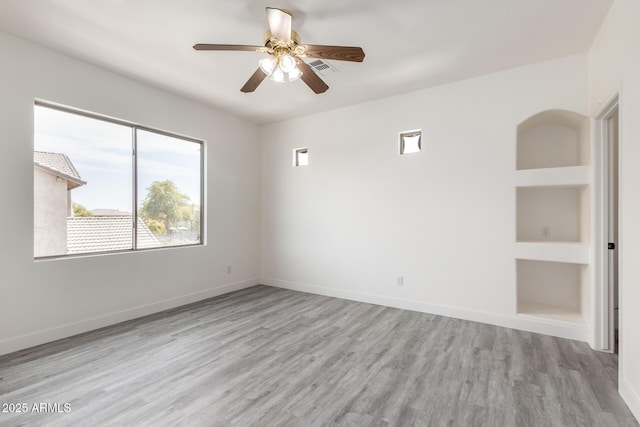 2302 S Canfield, Mesa, AZ 85209 - unfurnished room with healthy amount of natural light, wood finished floors, built in shelves, and ceiling fan