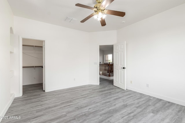 2302 S Canfield, Mesa, AZ 85209 - unfurnished bedroom featuring wood finished floors, baseboards, a spacious closet, and ceiling fan