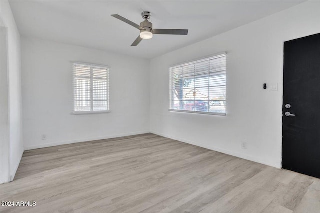 empty room with light hardwood / wood-style flooring, plenty of natural light, and ceiling fan