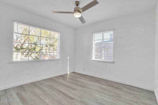 spare room with ceiling fan, light hardwood / wood-style floors, and a wealth of natural light