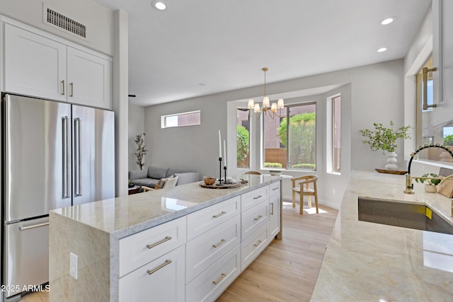 3624 N Paseo Del Sol, Mesa, AZ 85207 - kitchen with high quality fridge, a sink, light wood-style floors, light stone counters, and a chandelier