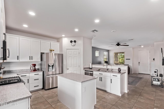 932 W Capulin Trl, San Tan Valley, AZ 85140 - kitchen with appliances with stainless steel finishes, a sink, a peninsula, a ceiling fan, and a kitchen island