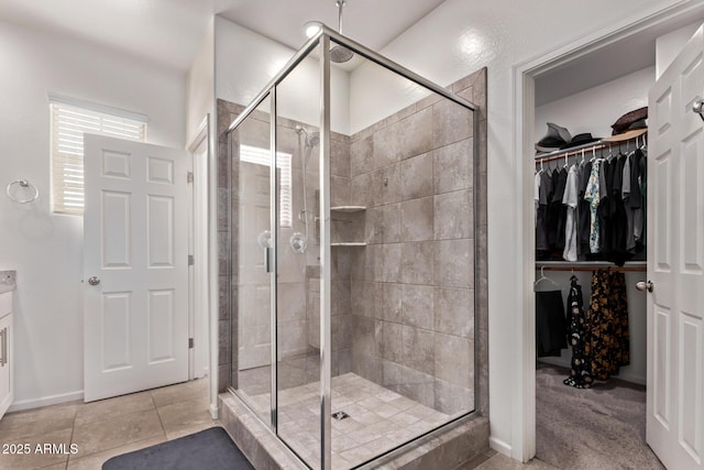 932 W Capulin Trl, San Tan Valley, AZ 85140 - bathroom with a stall shower, a spacious closet, vanity, and tile patterned flooring