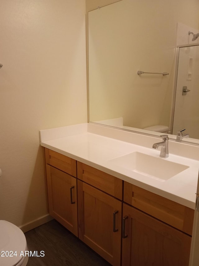 bathroom with wood-type flooring, vanity, toilet, and an enclosed shower