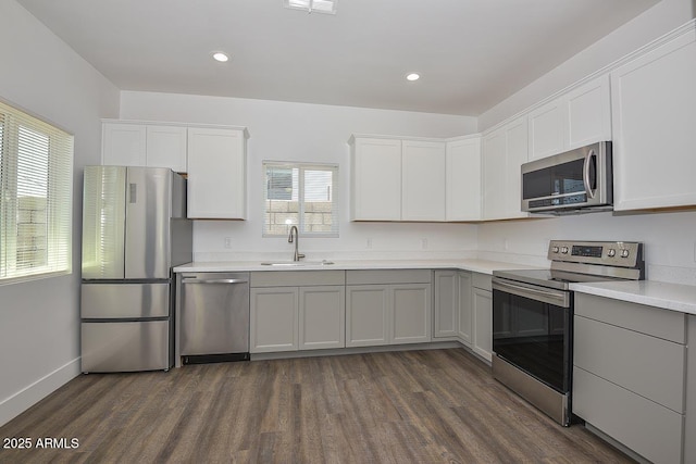 3831 N 8th St, Phoenix, AZ 85014 - kitchen with stainless steel appliances, a sink, dark wood-type flooring, light countertops, and white cabinets