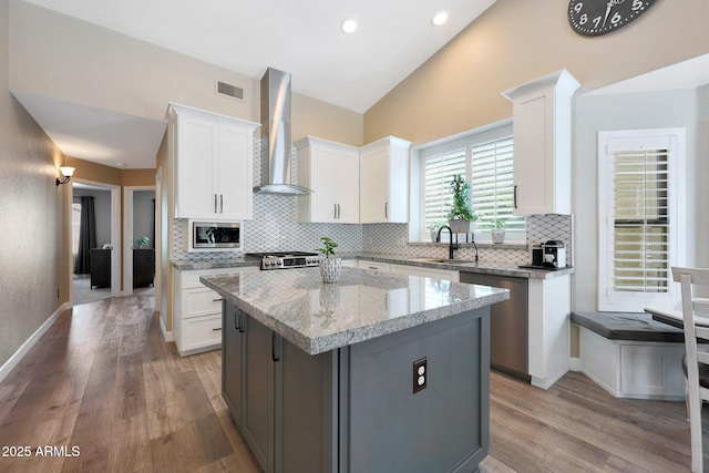 26647 N 43rd St N, Cave Creek, AZ 85331 - kitchen with wall chimney range hood, appliances with stainless steel finishes, decorative backsplash, light wood-type flooring, and lofted ceiling