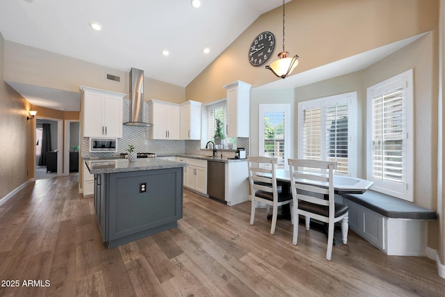 26647 N 43rd St N, Cave Creek, AZ 85331 - kitchen with wall chimney range hood, appliances with stainless steel finishes, a kitchen island, white cabinets, and backsplash