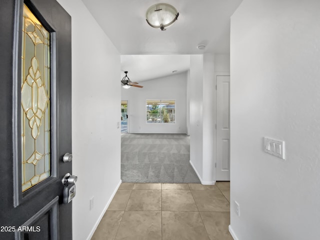 carpeted entrance foyer featuring ceiling fan and vaulted ceiling