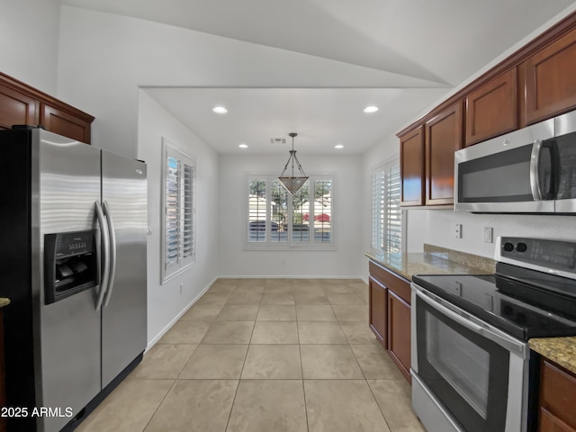 kitchen featuring light stone countertops, decorative light fixtures, lofted ceiling, light tile patterned flooring, and appliances with stainless steel finishes