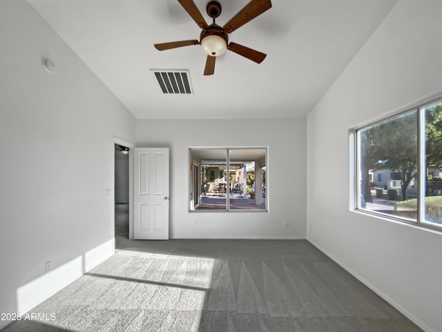 interior space featuring ceiling fan, dark carpet, and lofted ceiling