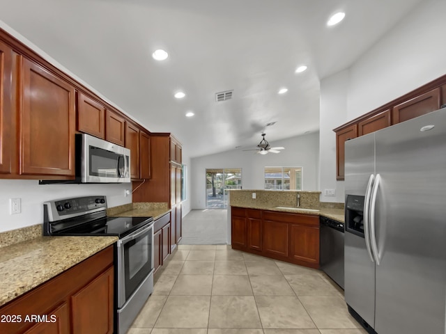 kitchen featuring ceiling fan, sink, light stone counters, lofted ceiling, and appliances with stainless steel finishes