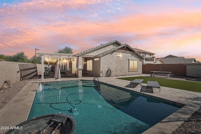 pool at dusk with a patio area and a pergola