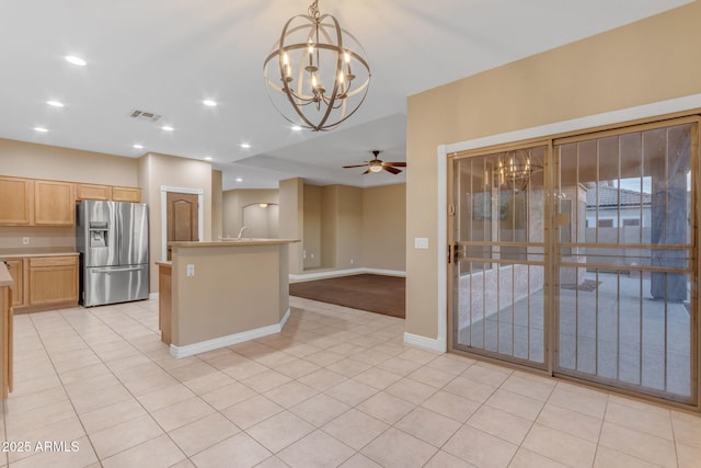 kitchen with stainless steel fridge with ice dispenser, hanging light fixtures, light tile patterned floors, light brown cabinets, and ceiling fan with notable chandelier