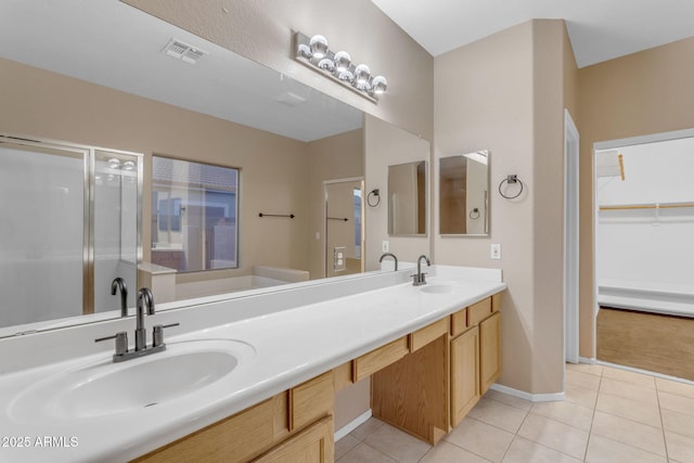 bathroom featuring tile patterned flooring, vanity, and a shower with door