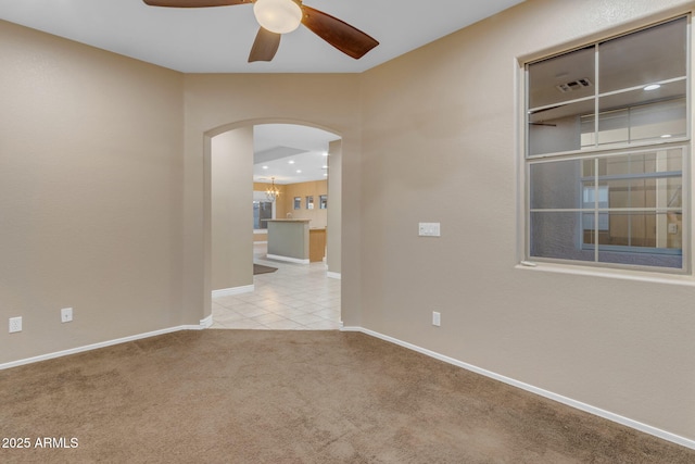 spare room with ceiling fan and light carpet