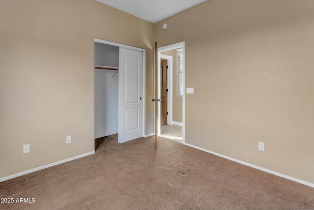 unfurnished bedroom featuring light colored carpet and a closet